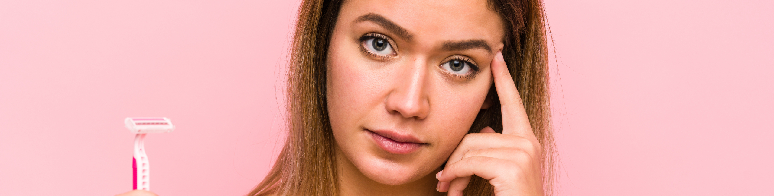 Mlada žena drži britvu i izgleda zabrinuto